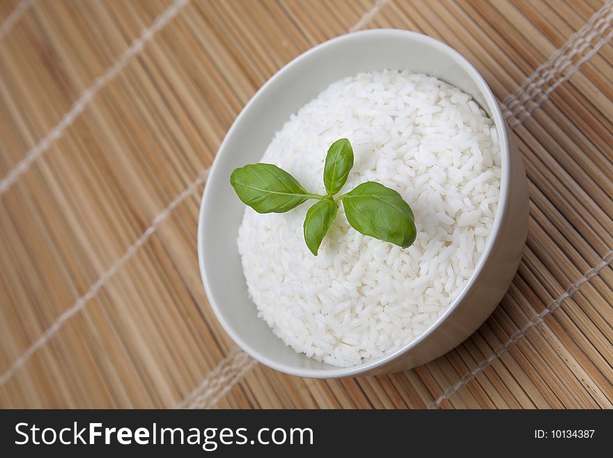 A bowl of perfectly cooked, plain Basmati rice, in an Asian style bowl, with a garnish of Thai Basil. A bowl of perfectly cooked, plain Basmati rice, in an Asian style bowl, with a garnish of Thai Basil