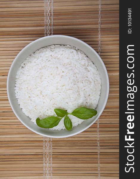 A bowl of perfectly cooked, plain Basmati rice, in an Asian style bowl, with a garnish of Thai Basil. A bowl of perfectly cooked, plain Basmati rice, in an Asian style bowl, with a garnish of Thai Basil