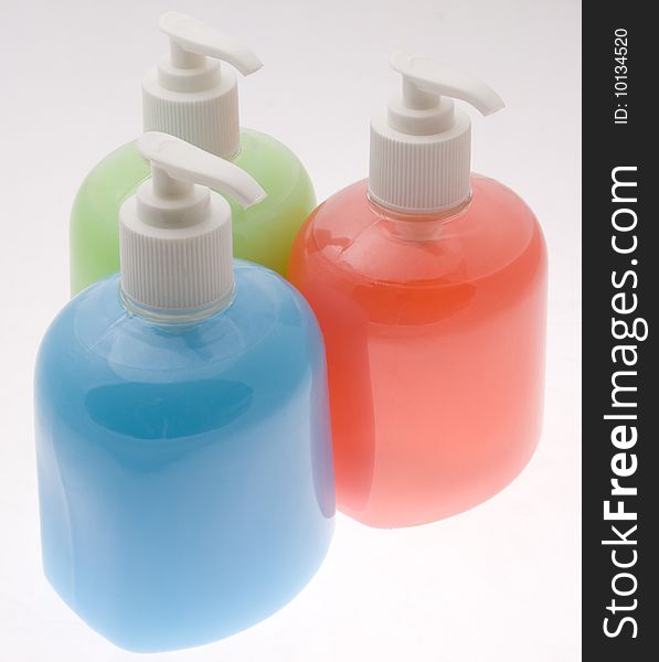 Three bottles filled with different coloured liquid soap. Three bottles filled with different coloured liquid soap