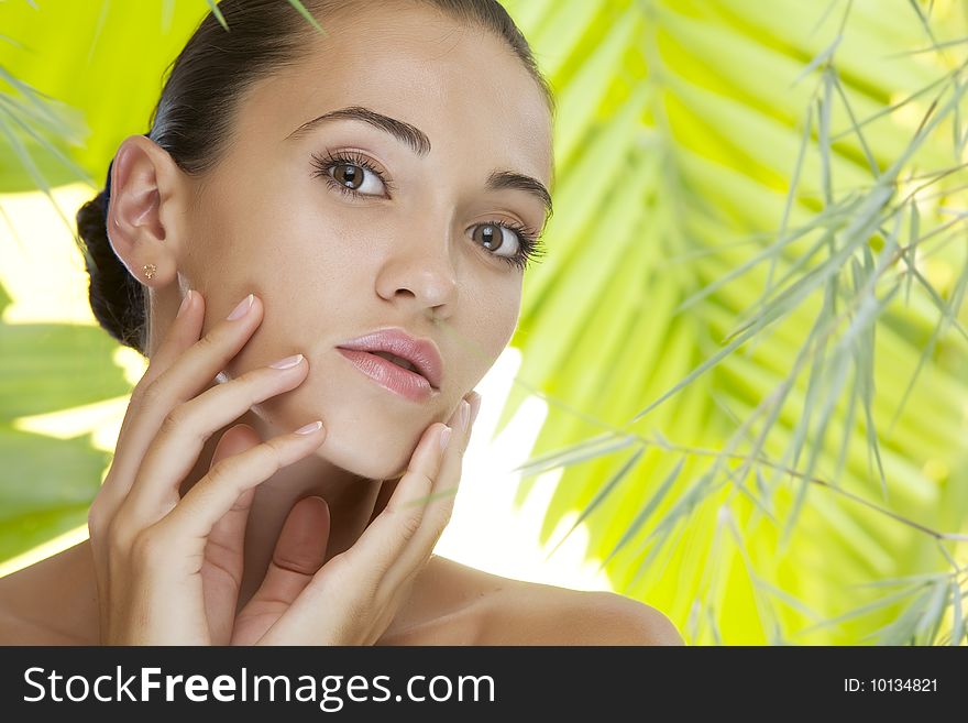 Portrait of young beautiful woman on green leafs back. Portrait of young beautiful woman on green leafs back