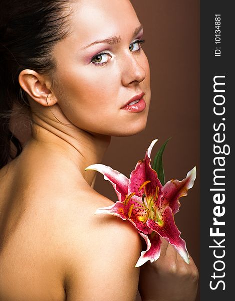 Beauty portrait of a young woman with a lily flower. Beauty portrait of a young woman with a lily flower