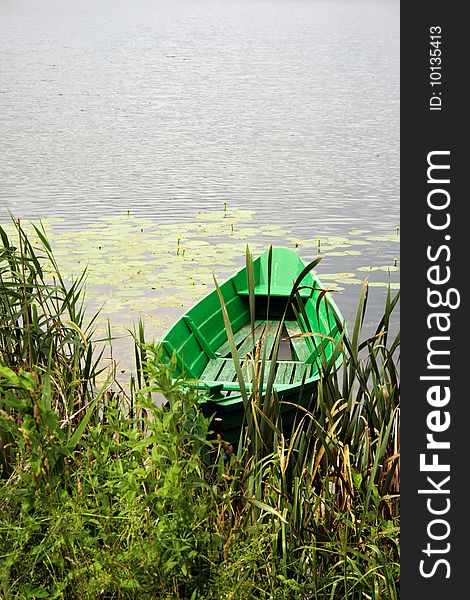 Small green boat on a calm lake