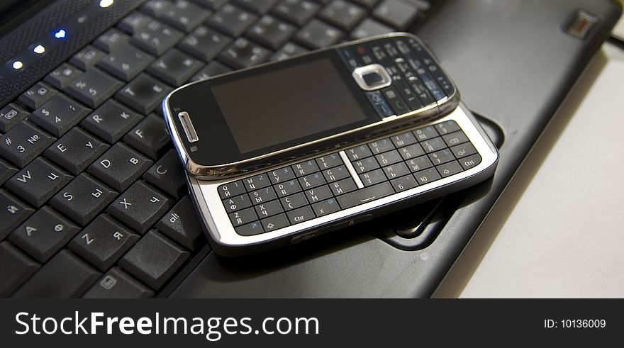 Modern Mobile phone on a laptop