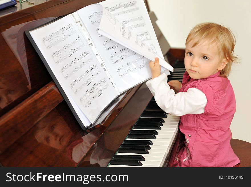 Beautiful little girl plays  piano