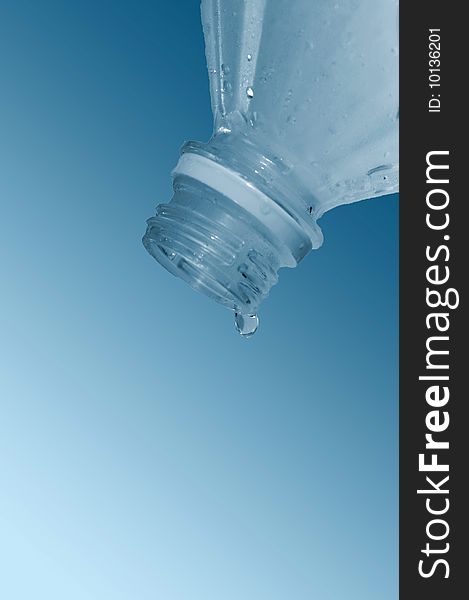 Water flows from  bottle on  blue background. Water flows from  bottle on  blue background