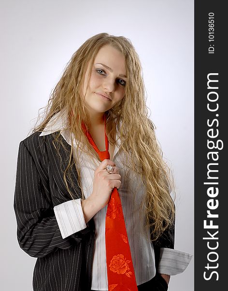Business women makes undefined expression on her face. She wears black jacket, white short and red tie. Business women makes undefined expression on her face. She wears black jacket, white short and red tie.