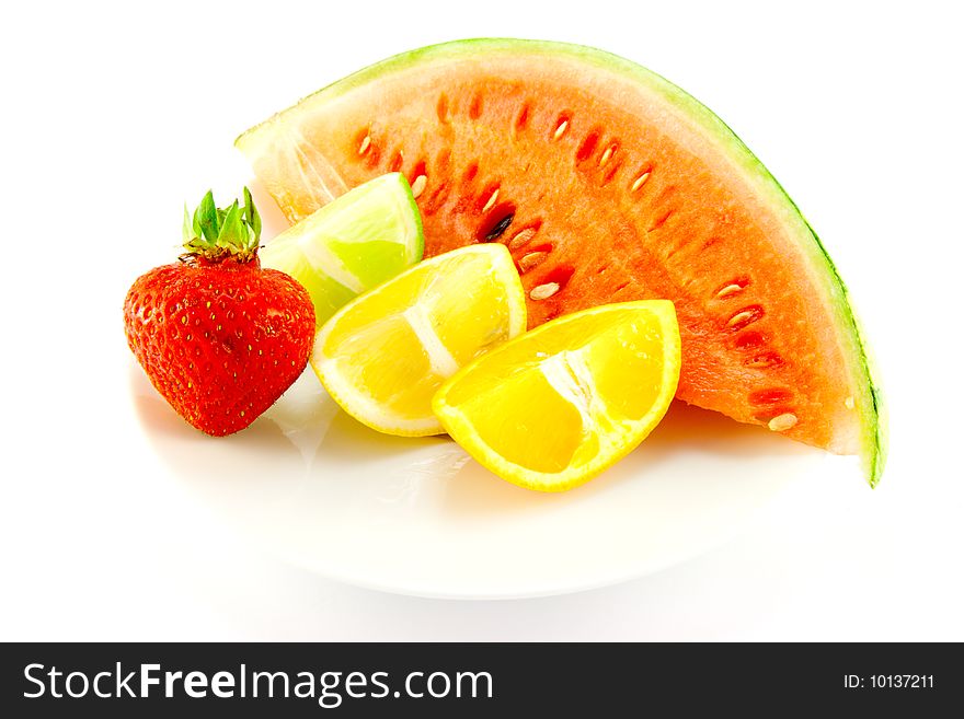 Lemon, lime and orange wedges with a red ripe strawberry and slice of juicy watermelon with a white background. Lemon, lime and orange wedges with a red ripe strawberry and slice of juicy watermelon with a white background