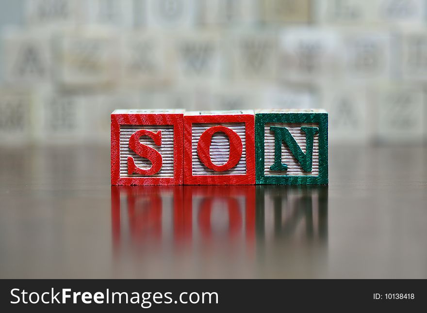 The word son spelled out in wooden letter blocks