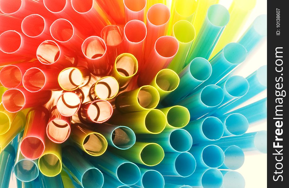 Colored drinking straws in close-up lit from behind
