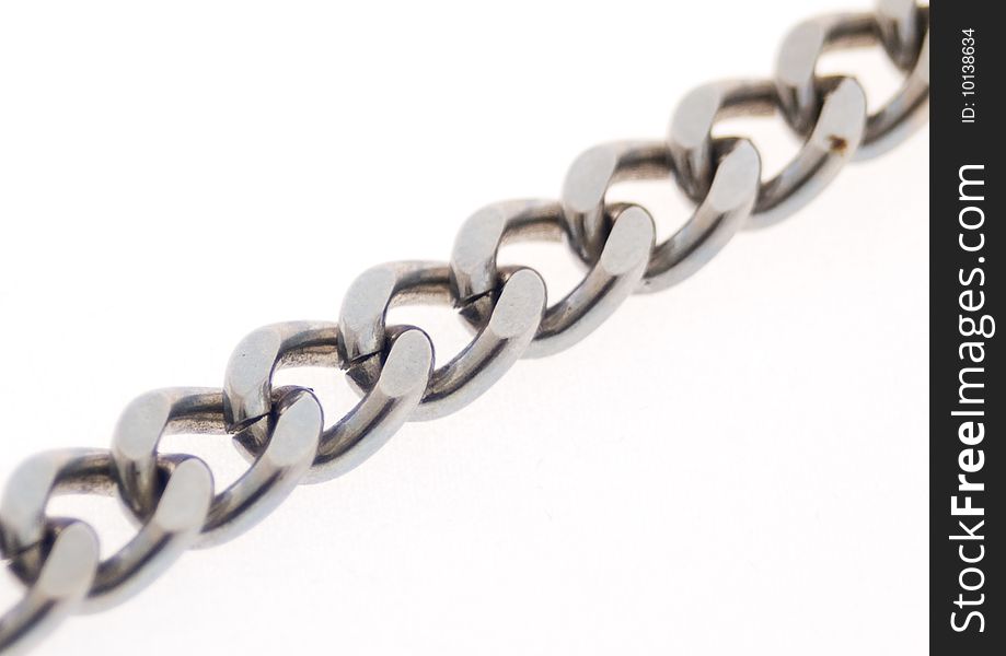 Silver-colored chain in diagonal against a white background with the middle links in focus