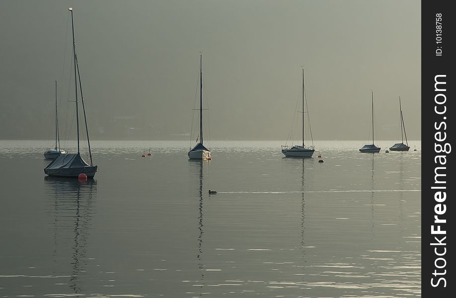 Boats in the early morning fog on lake tegernsee in Germany