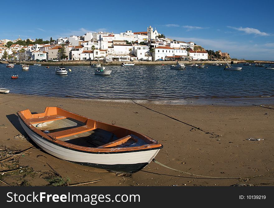 Fishing boat with Ferragudo village in the background. Fishing boat with Ferragudo village in the background.