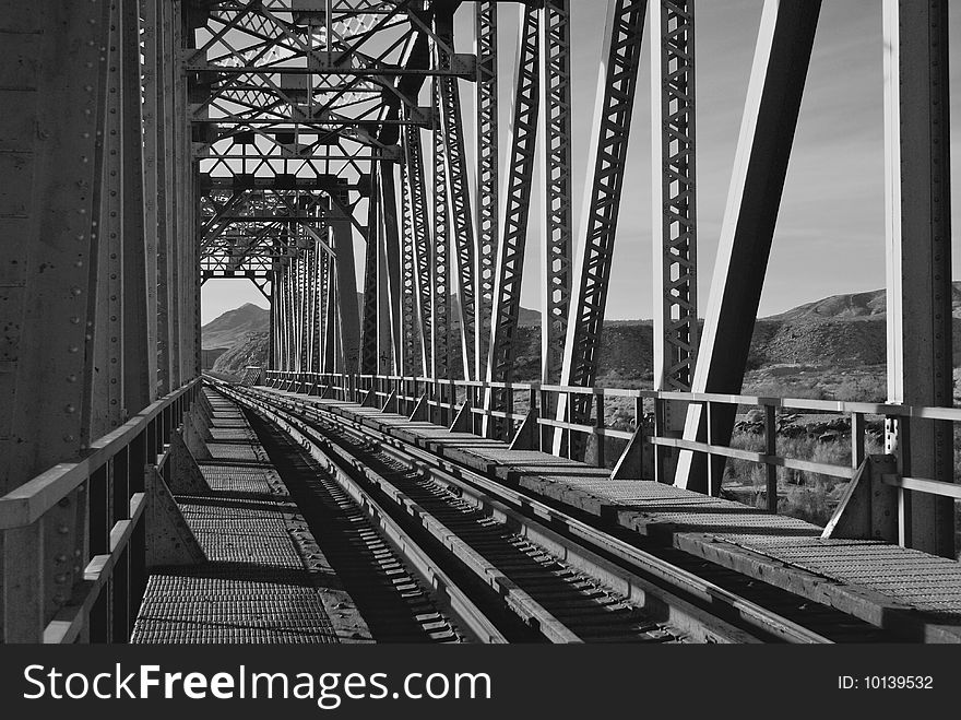 Rails on a railroad trestle over a river