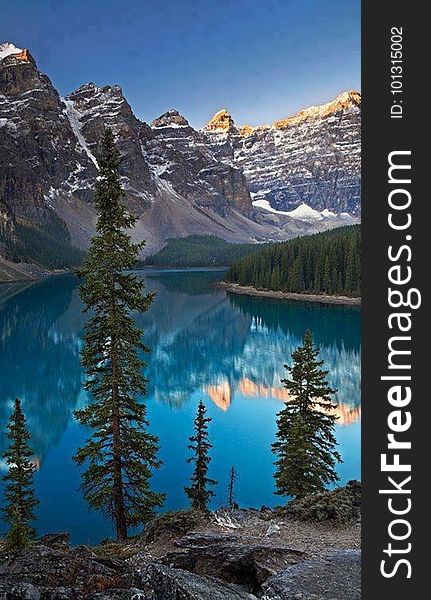 A lake in a mountain valley with the peaks reflecting from the water. A lake in a mountain valley with the peaks reflecting from the water.