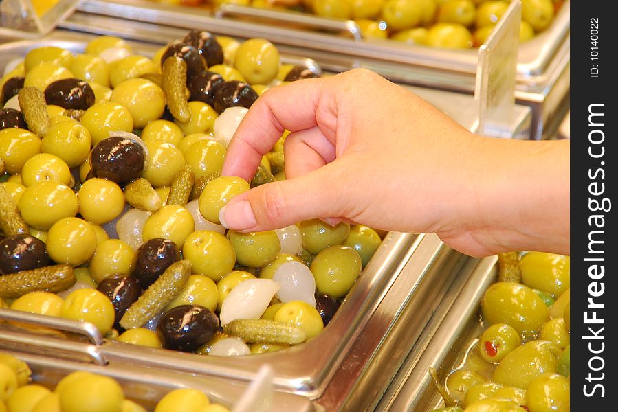 Hand picking up an olive. Hand picking up an olive