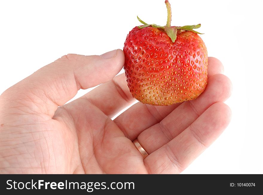 Red strawberry in a hand on a white background