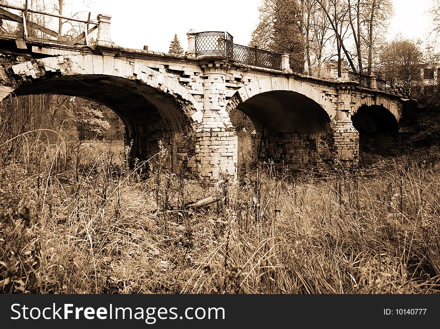 Classic destroyed old bridge in sepia. Classic destroyed old bridge in sepia