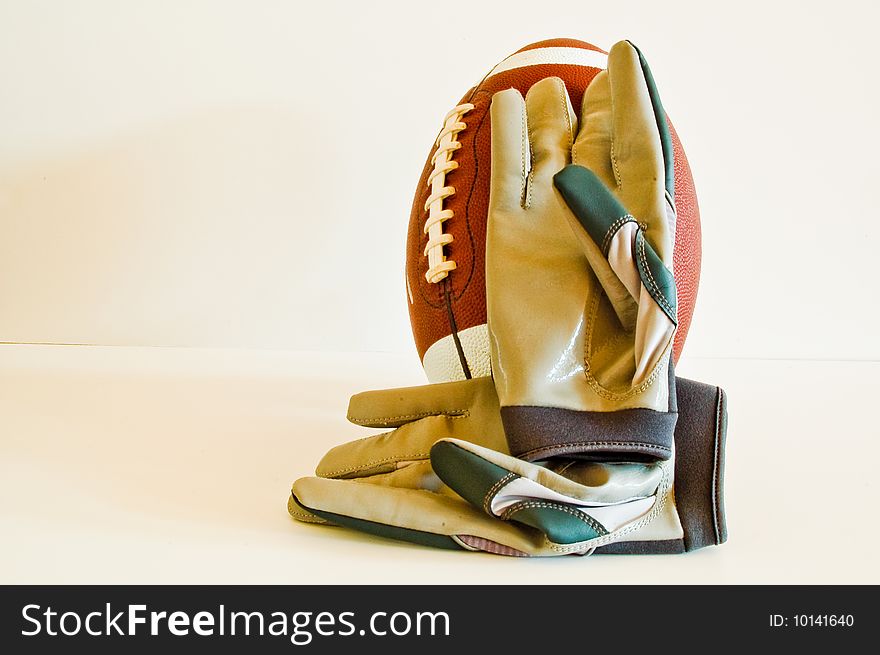 A Pair of Receiver's Gloves Rest on a Football. A Pair of Receiver's Gloves Rest on a Football