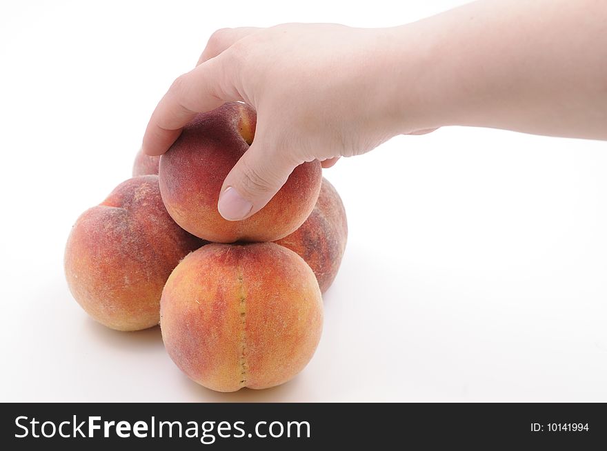 Hand taking a peach. Isolated on white background