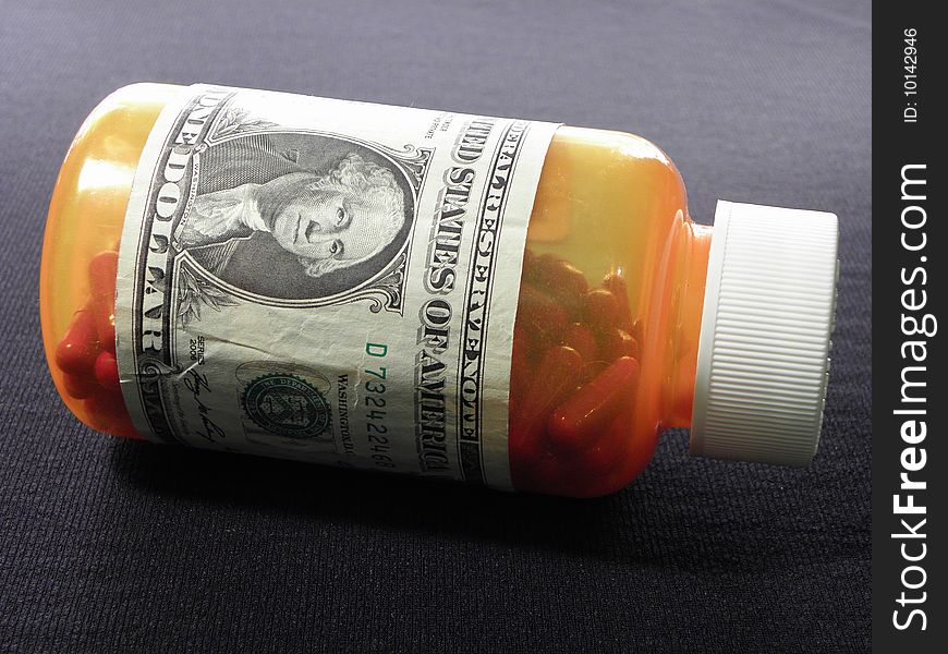 Pill bottle with red pills wraped in dollar bill. Pill bottle with red pills wraped in dollar bill.