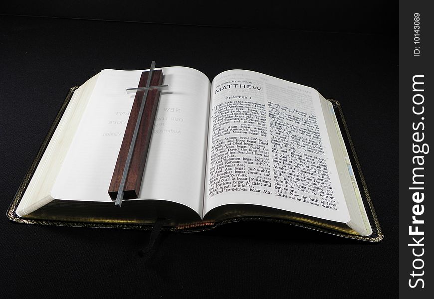 Christian Bible overlaid with Silver and wood cross. Christian Bible overlaid with Silver and wood cross