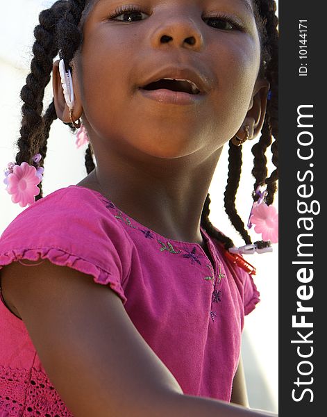 An adorable little african american girl in a pink shirt. An adorable little african american girl in a pink shirt
