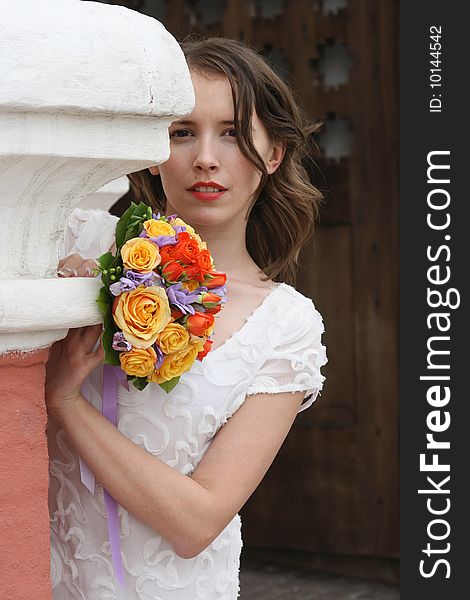 Portrait of the beautiful bride with a wedding bouquet from roses