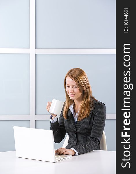 Business woman in modern office with laptop and coffee