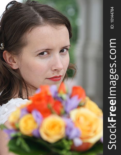 Portrait of the beautiful bride with a wedding bouquet from roses