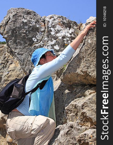 Tourist woman climbing on the rock