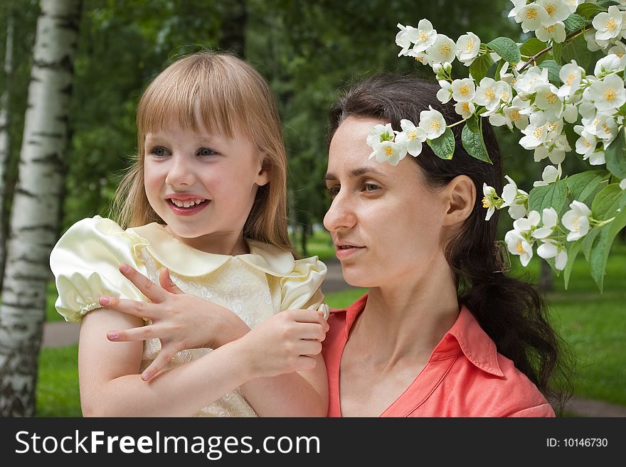 Mother holding her daughter near  jasmine flowers. Mother holding her daughter near  jasmine flowers