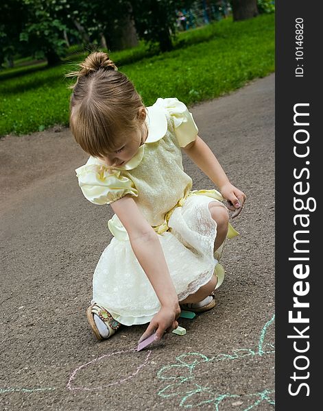 Girl drawing with a crayoun on asphalt. Girl drawing with a crayoun on asphalt