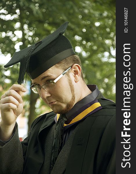 Funny graduate looks on his cap's tassel
