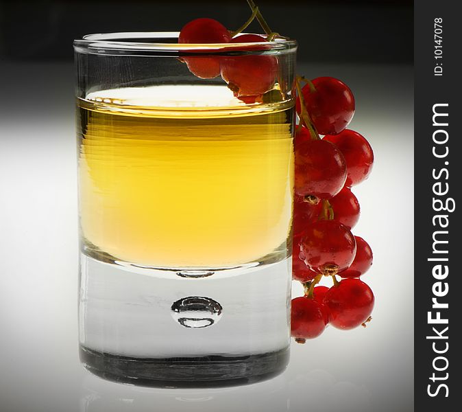 Shot glas with alcohol and red fruit hanging over the edge. Shot glas with alcohol and red fruit hanging over the edge.