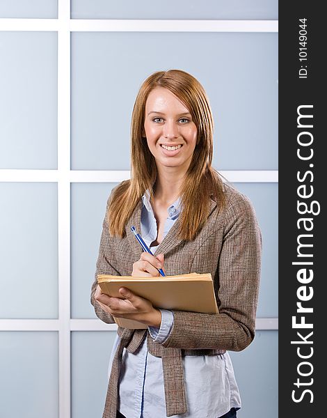 Business Woman Writing notes at desk in a modern office