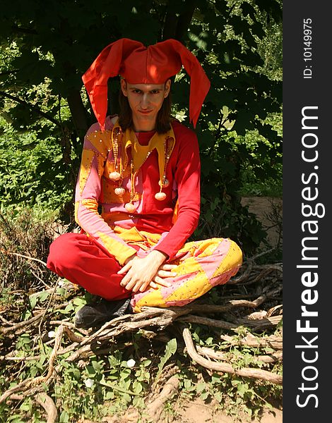 Man dressed in a clown`s costume walking outdoor