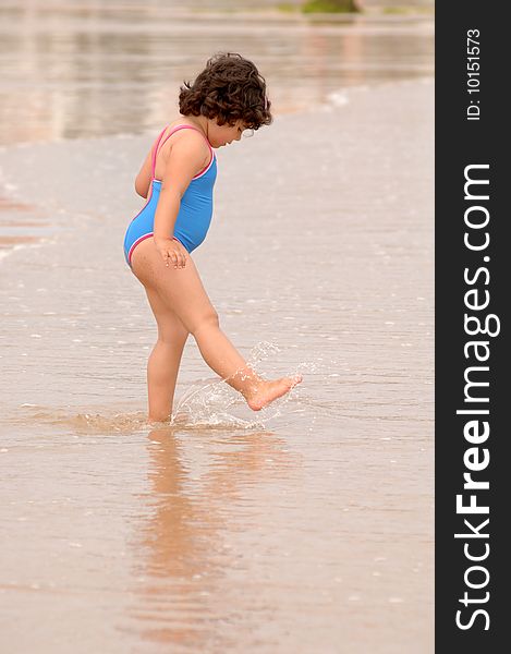 Cute little girl on the beach playing