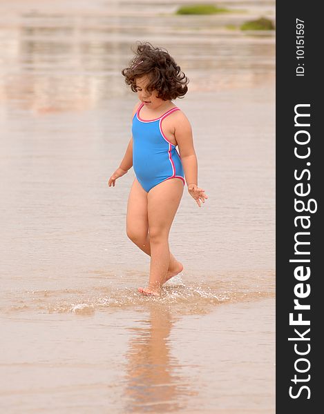 Cute little girl on the beach playing