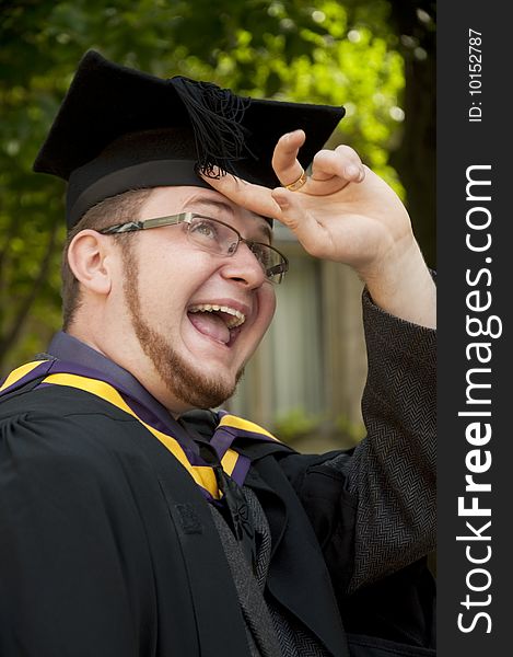 Funny graduate looks on his cap's tassel