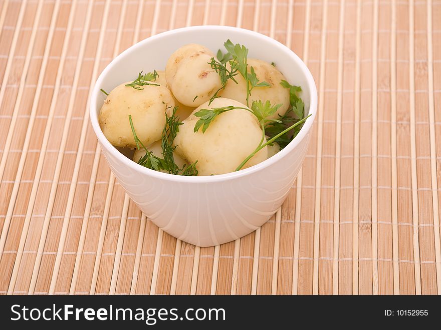 Boiled potatoes with parsley on a bamboo