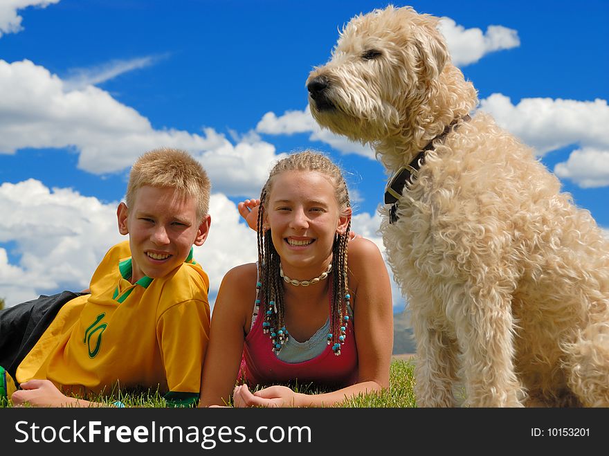 Brother and sister on grass area wit their pet. Brother and sister on grass area wit their pet