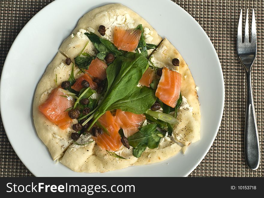 Handmade salmon pizza with spinach