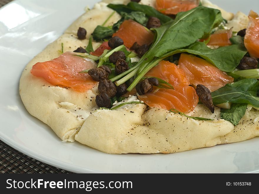 Handmade salmon pizza with spinach