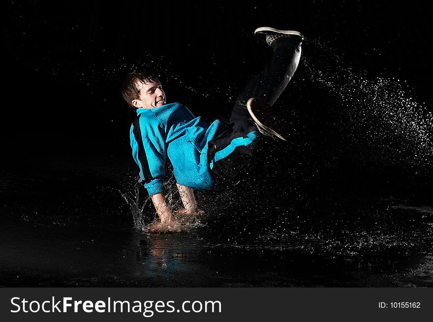 Stylish and young modern style dancer is posing in water