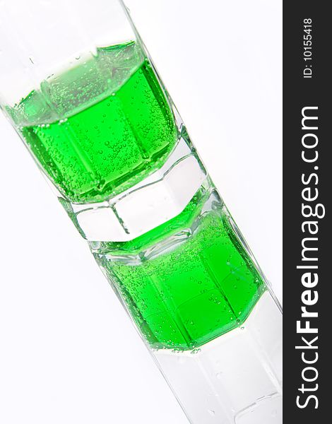 Green soda in a glass on a white background