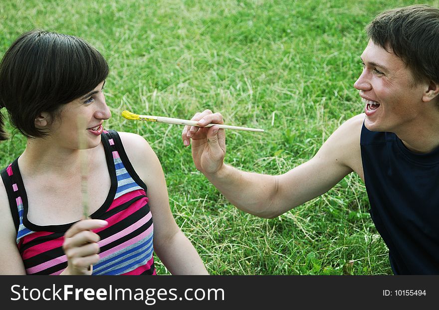Young man and the woman draw on an open-air. Young man and the woman draw on an open-air