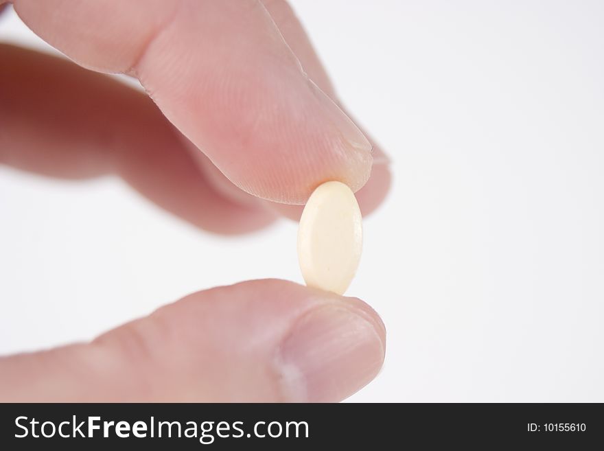 Fingers Holding A Cream Pill