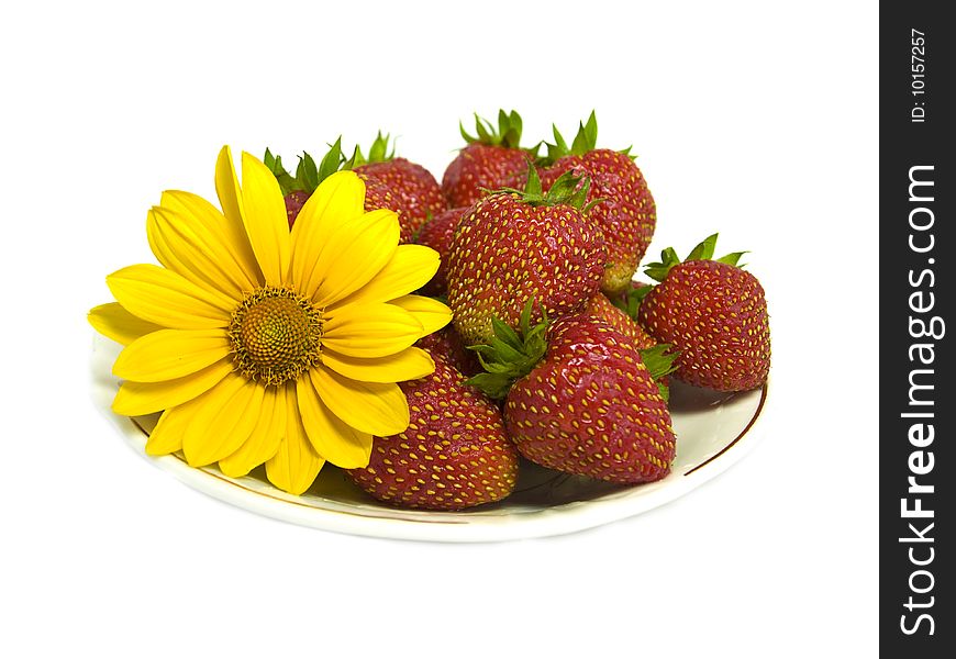 Strawberries and yellow flower isolated on white