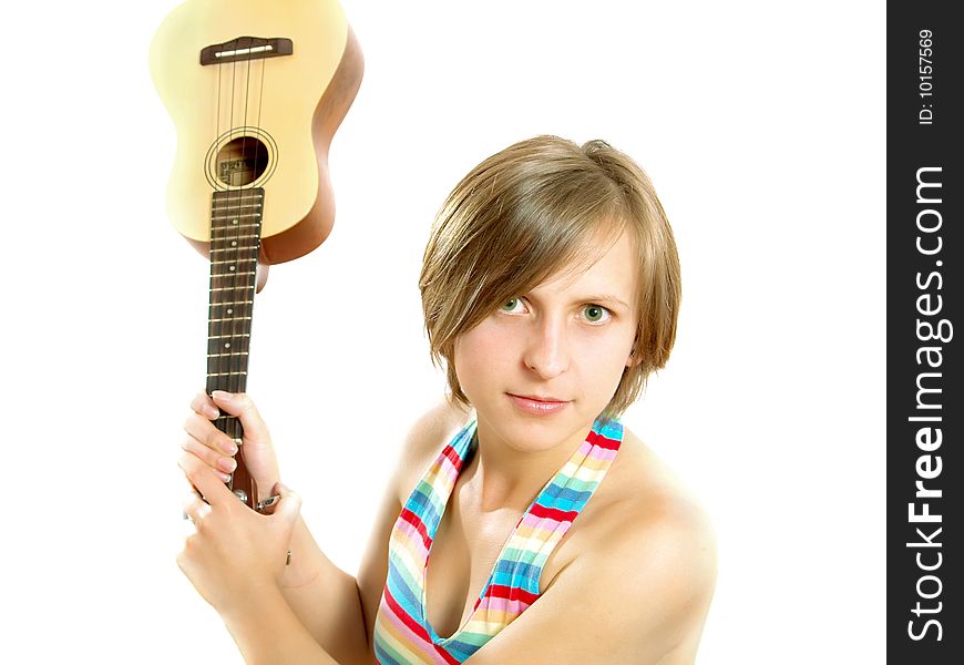 Portrait of a cute Caucasian blond girl with a nice colorful striped summer dress who is angry and she want to fight with an ukulele (small Hawaiian guitar). Isolated on white. Portrait of a cute Caucasian blond girl with a nice colorful striped summer dress who is angry and she want to fight with an ukulele (small Hawaiian guitar). Isolated on white.