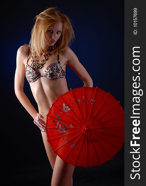 Portrait of a beautiful blond woman in lingerie with red parasol. Portrait of a beautiful blond woman in lingerie with red parasol